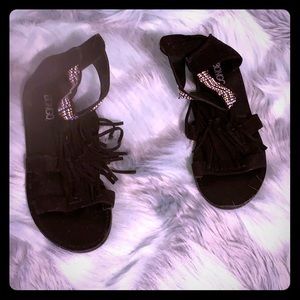 Black faux suede gladiator sandals with fringe